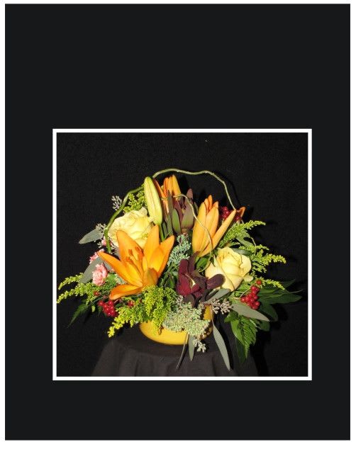 Yellow and orange floral arrangement in a yellow container
