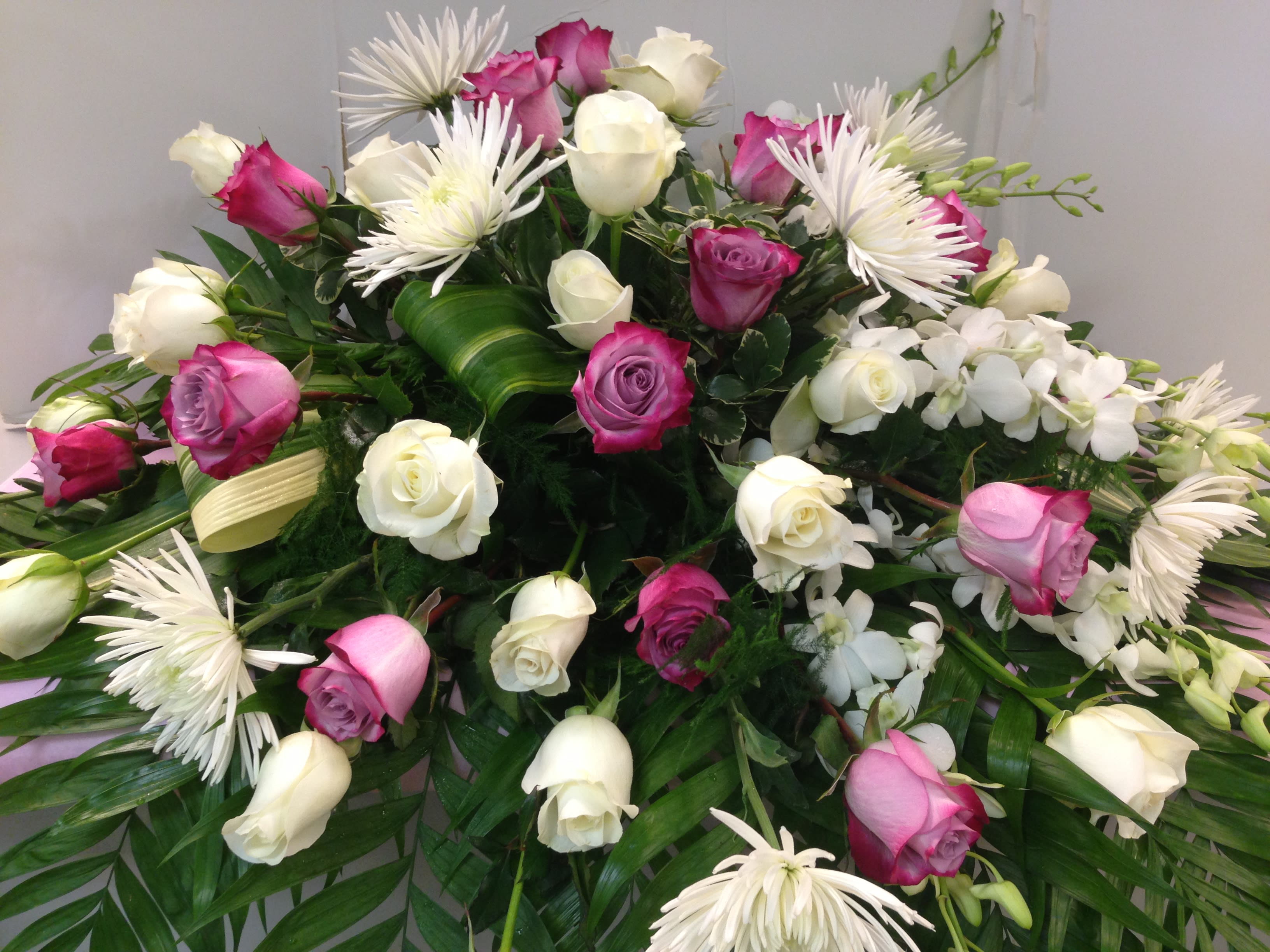Pink and white roses with white spider mums in a large arrangement