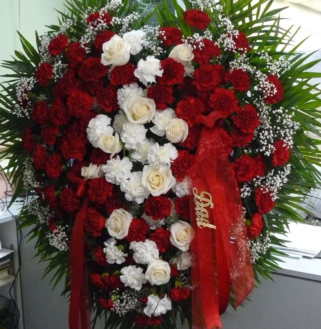 Broken Heart Spray    - Base designed with Carnations,  Break  consist of Roses/Carnations, , Assorted Fancy Greens, Babies-Breath, Ribbon drapes the piece.