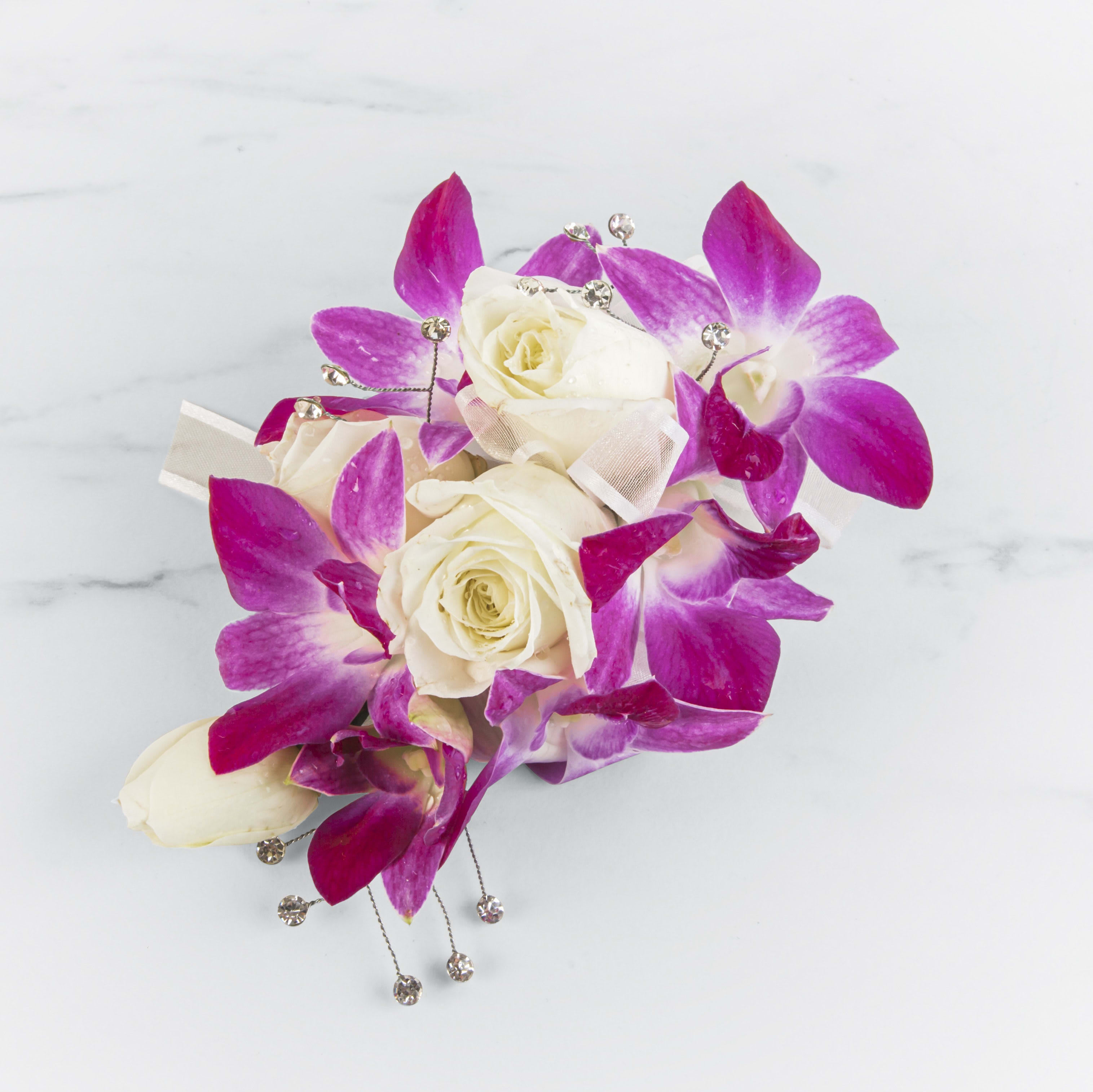 White roses with bright pink orchids and jeweled accents