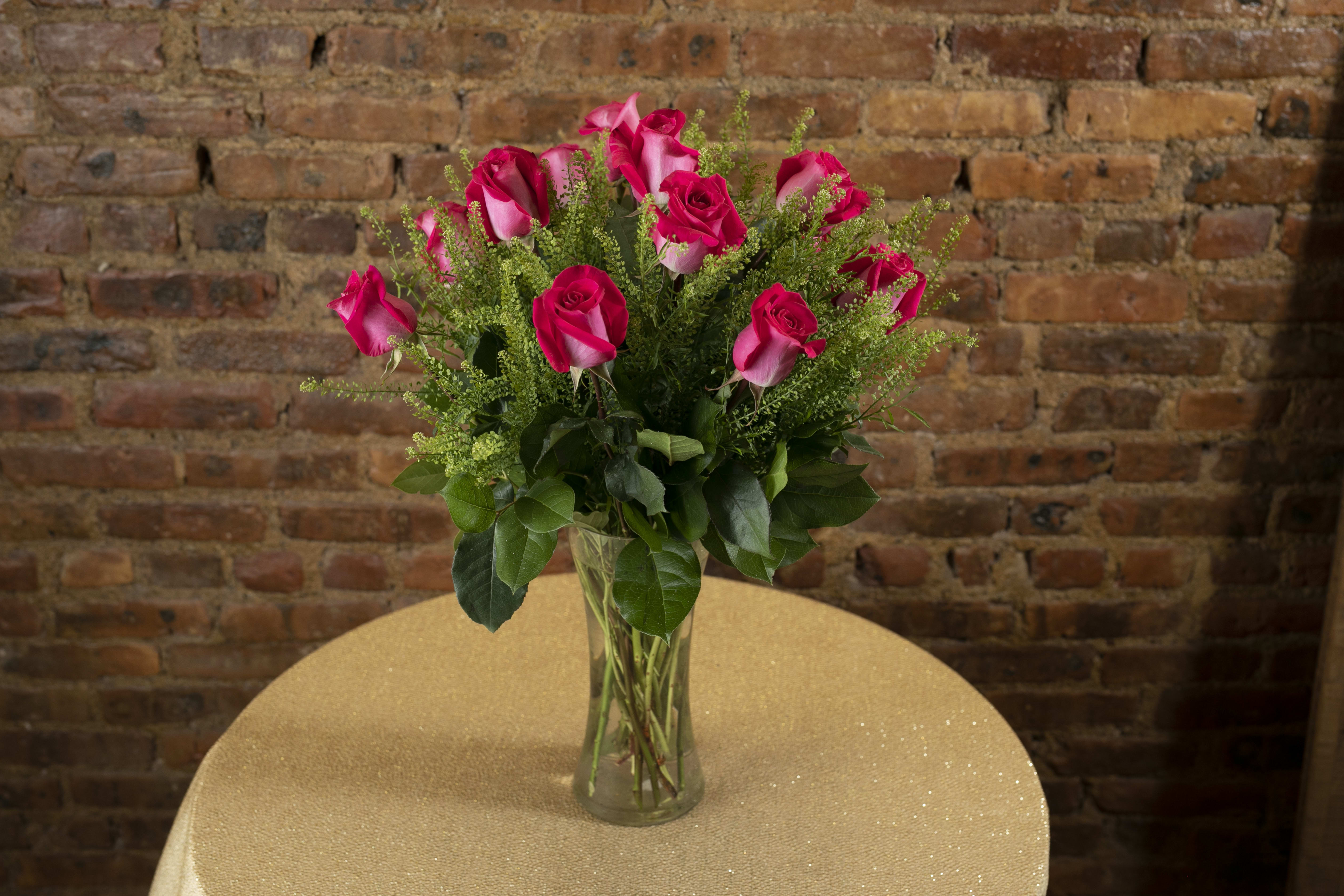Pink roses in a clear glass vase on a table