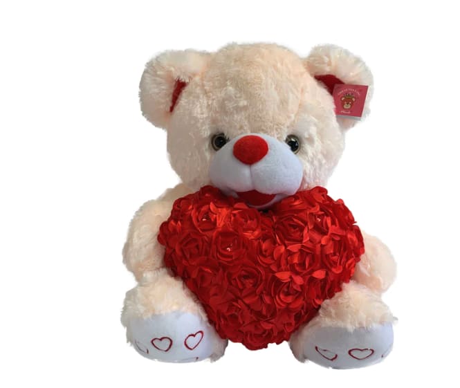 White teddy bear holding a red heart