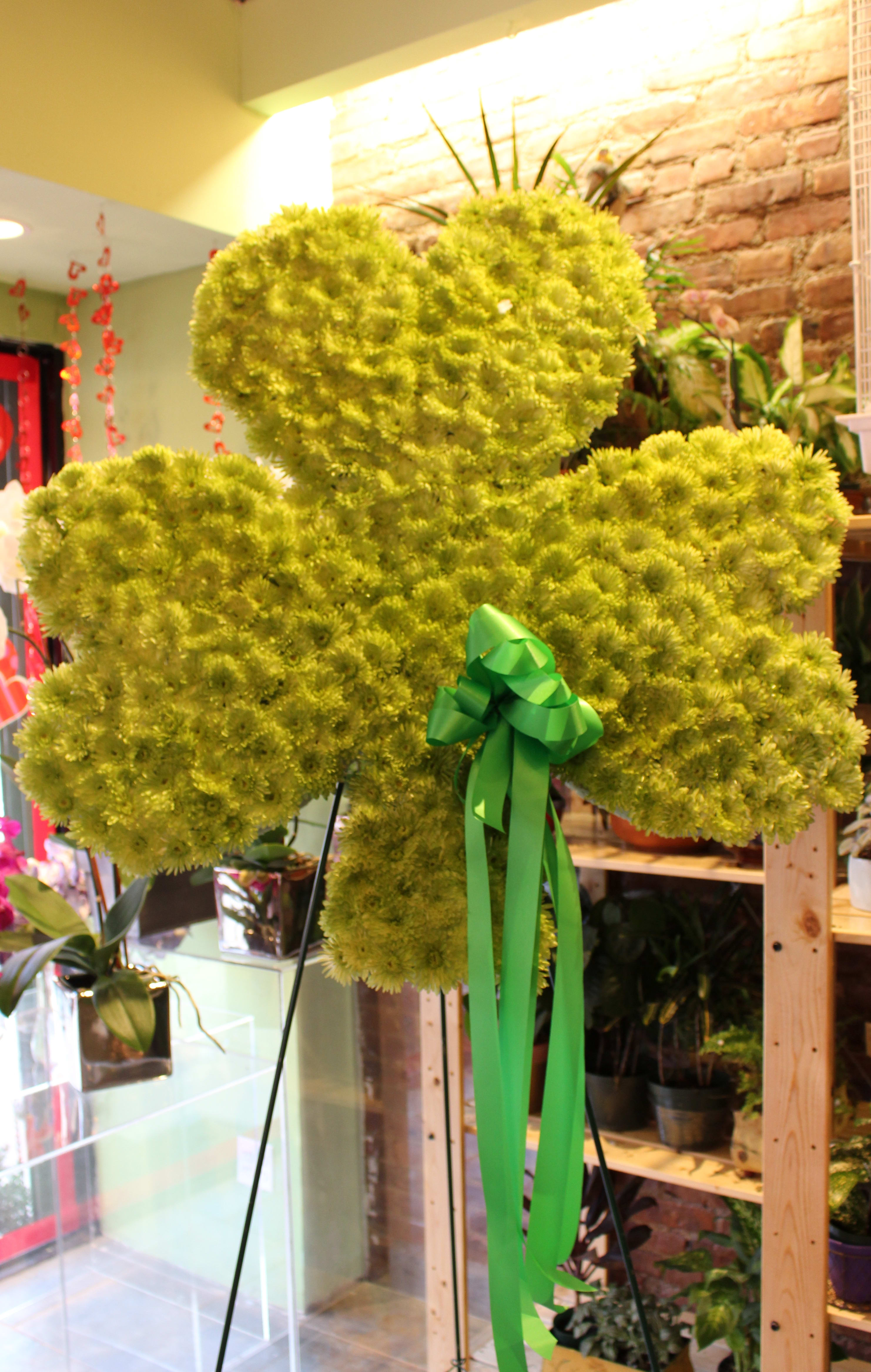 Large green floral teddy bear with a ribbon bow