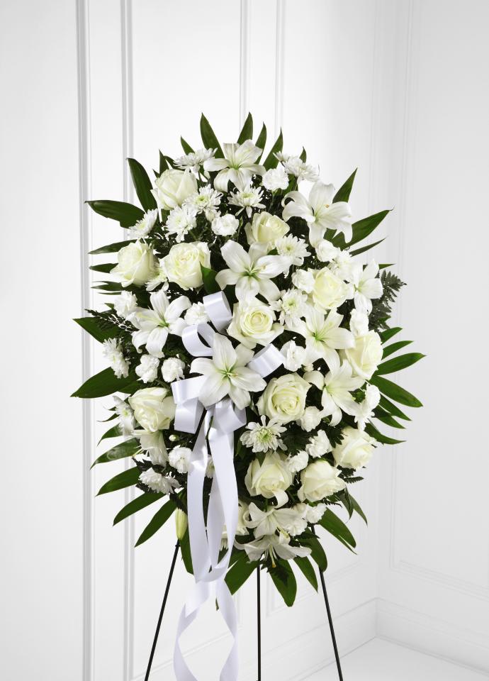 FTD Exquisite Tribute Standing Spray - The FTD Exquisite Tribute Standing Spray is an elegant display of  sweet serenity. White roses, Asiatic lilies, chrysanthemums and mini  carnations are artfully arranged amongst emerald palm fronds and lush  greens. Accented by white satin ribbon and standing on a wire easel,  this standing spray is an outstanding way to honor the life of your  loved one. 32""h x 20""w