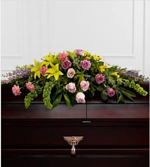 The FTD® Forever Beloved™ Casket Spray -  The FTD® Forever Beloved™ Casket Spray beautifully illuminates the atmosphere of thier final farewell service. Lavender roses, pink roses, lavender larkspur, pink carnations, Bells of Ireland, yellow Asiatic lilies, yellow freesia, solidago and lush greens are arranged to create an extravagant display of floral beauty that offers comfort and peace to the friends and family of the deceased. Approximately 43"W x 30"D. Your purchase includes a complimentary personalized gift message.