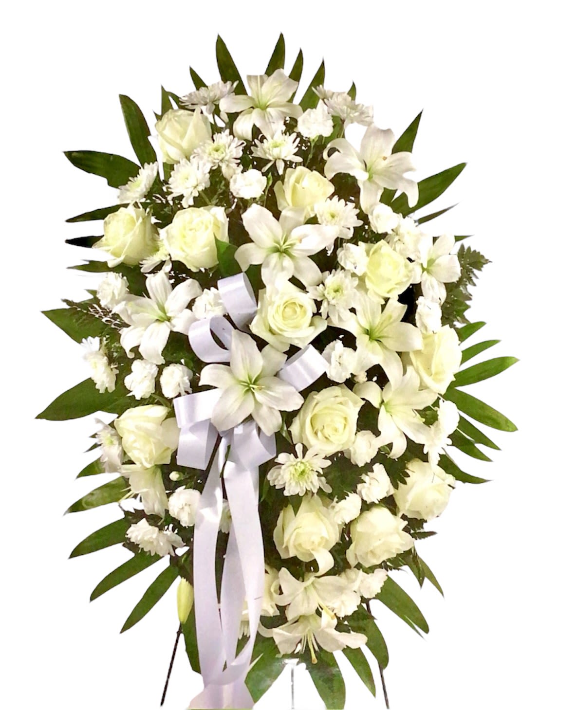 White floral standing spray with roses and lilies, accented by a pale ribbon
