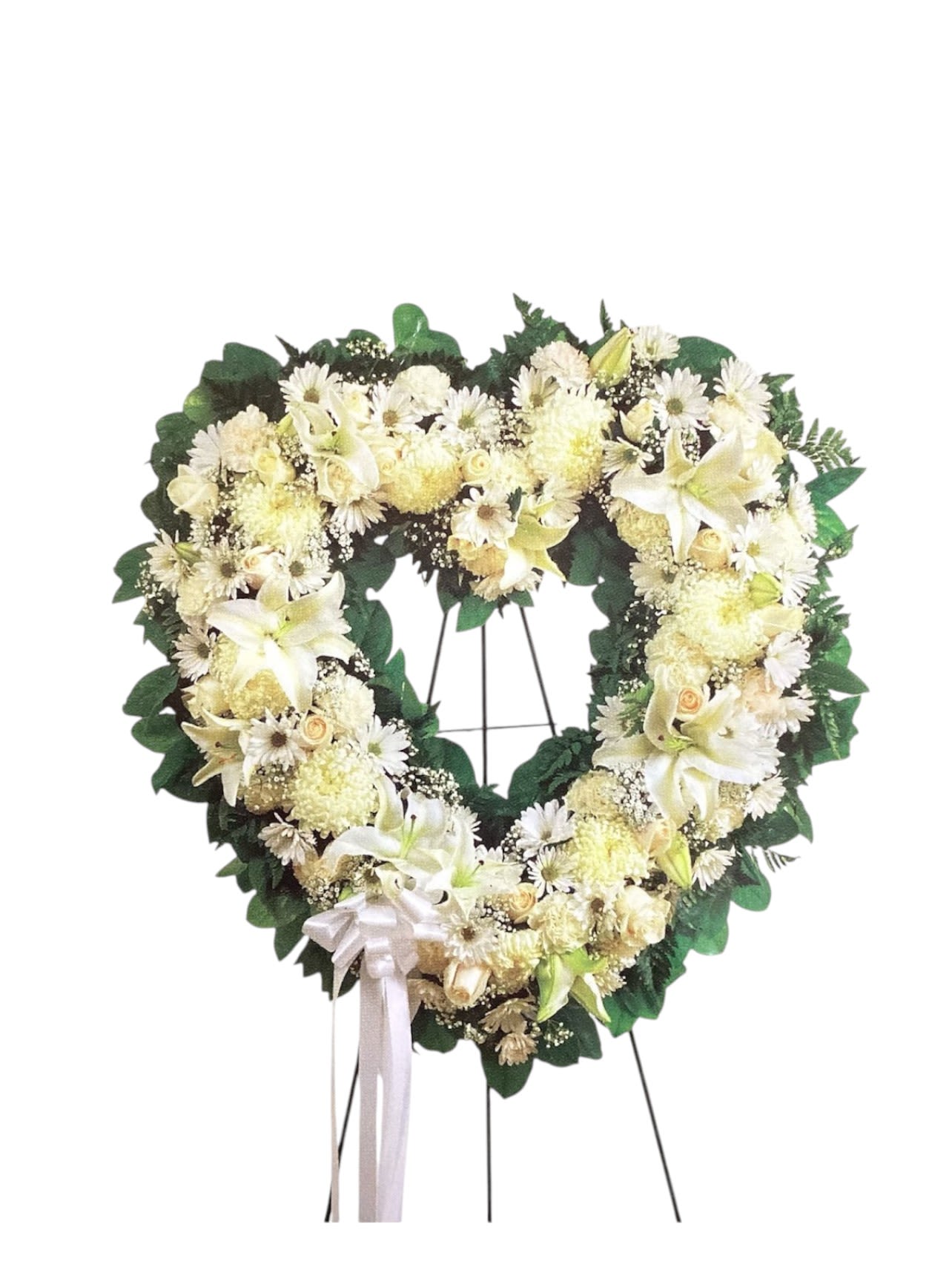 Heart-shaped white floral wreath on a stand with a ribbon