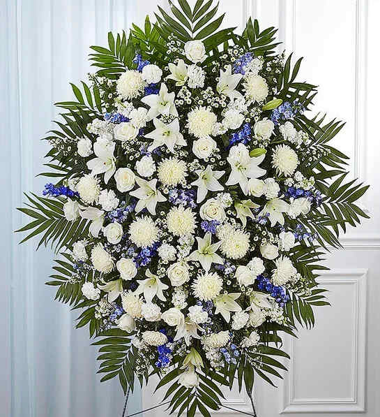 Blue &amp; White Funeral Standing Spray - When someone so dear passes, a standing tribute is a fitting way to pay respects. Our impressive standing spray arrangement, meticulously handcrafted by expert florists with pristine white and rich blue blooms, is a lush, full presentation that makes for a proud and respectful commemoration. 