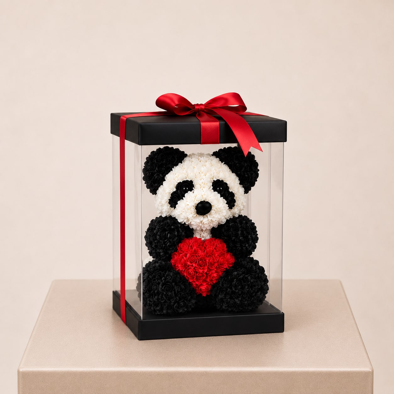 Panda-shaped floral gift in a clear box with a red ribbon and heart