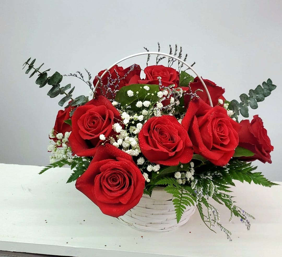 Basket arrangement of red roses with baby's breath and greenery