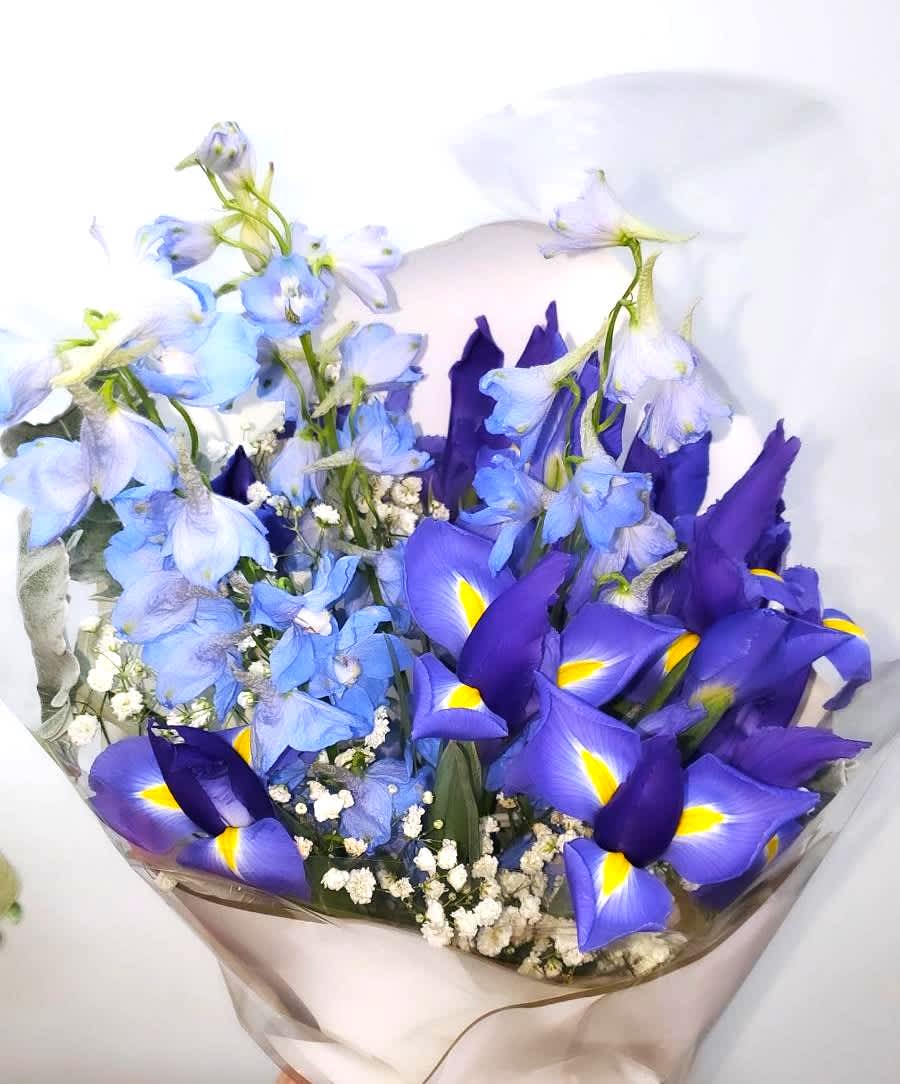 Bouquet of blue and purple flowers wrapped in clear paper