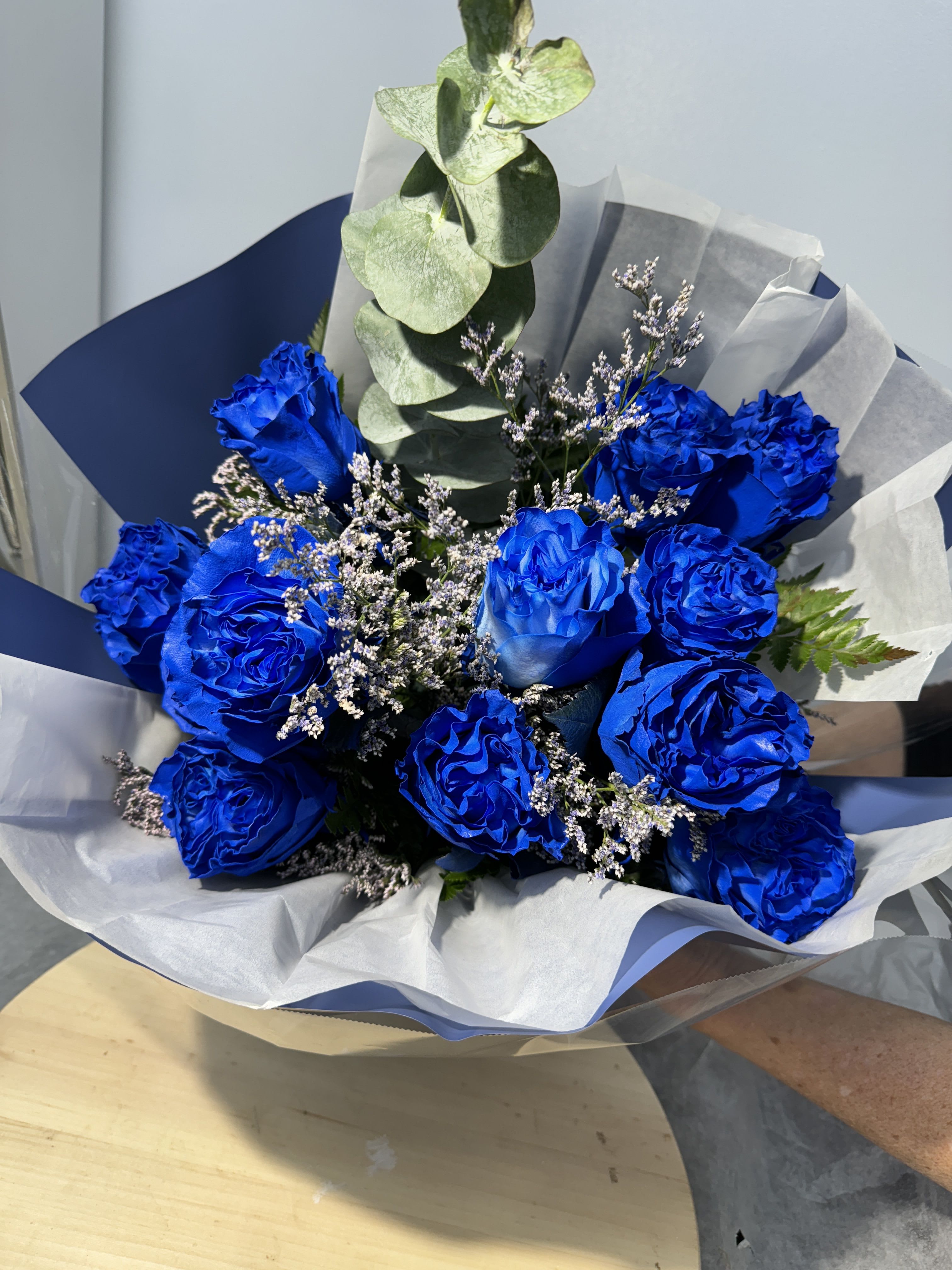 Bouquet of vivid blue roses with white filler and eucalyptus