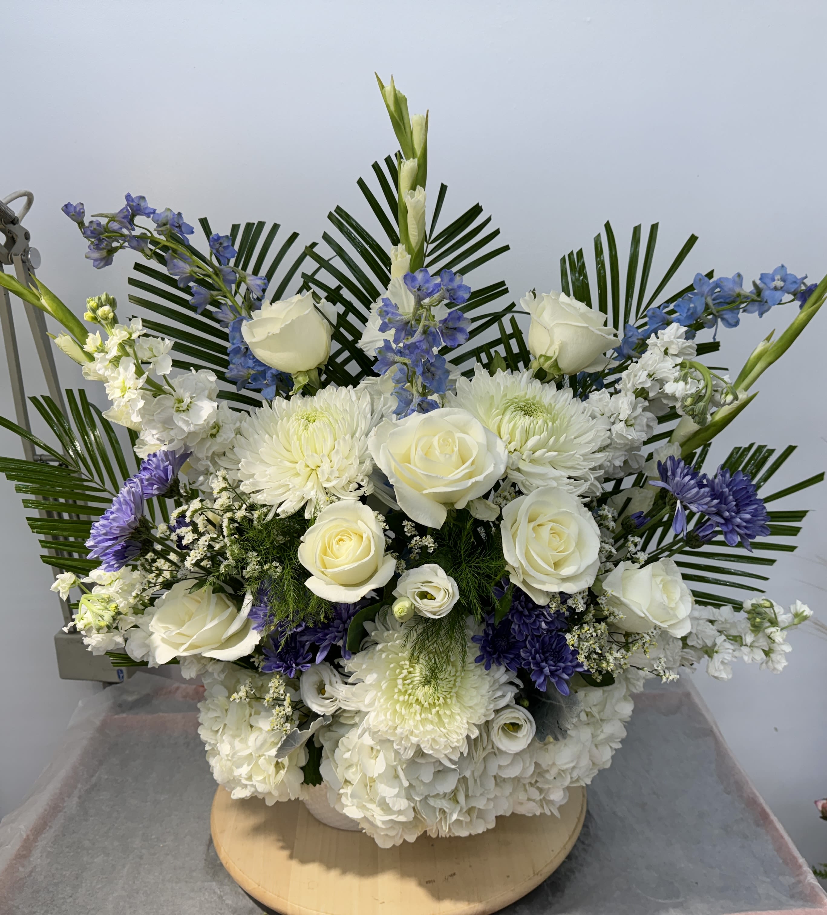 White roses and chrysanthemums with blue flowers in a low arrangement