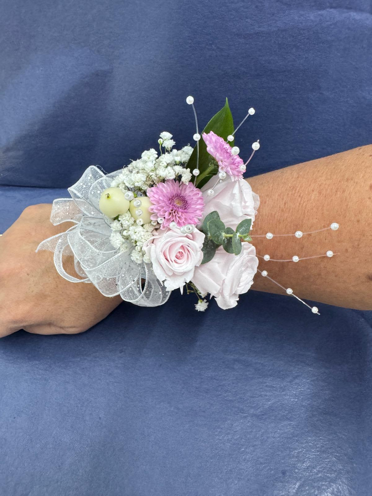 Pink and white wrist corsage with ribbon and pearl accents