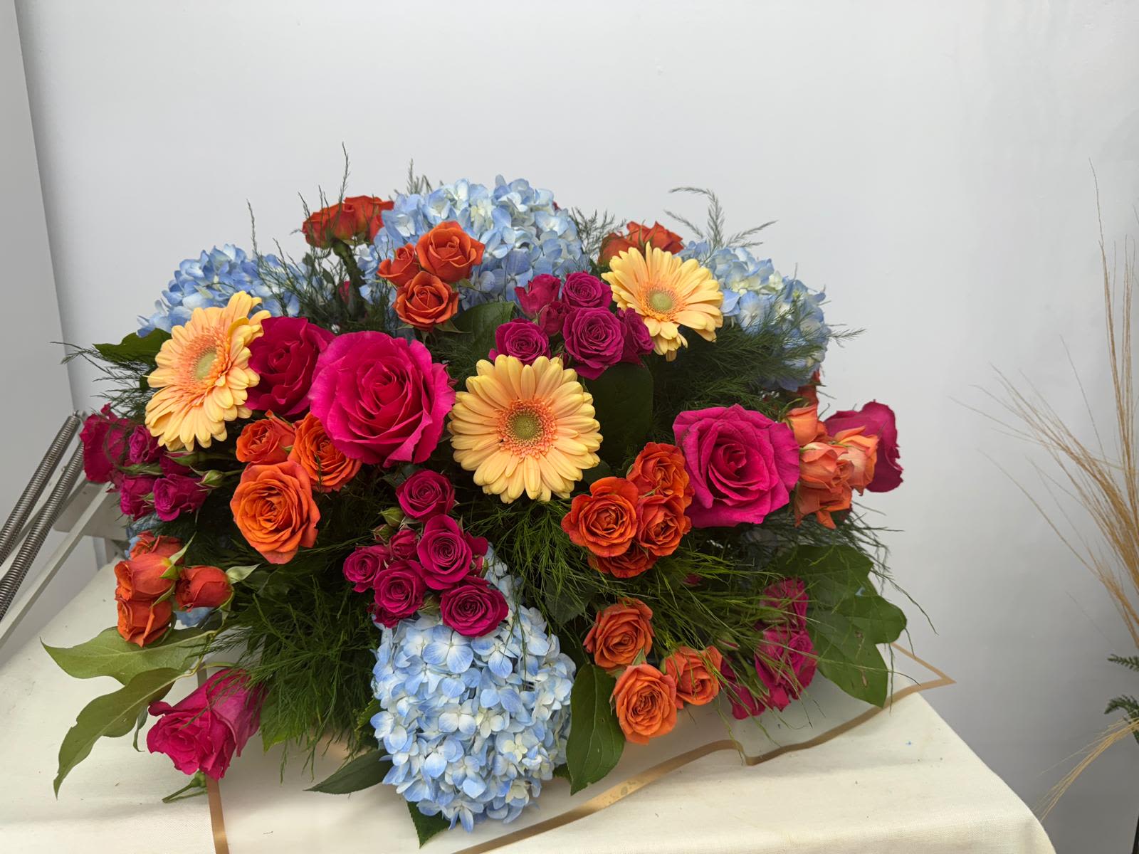 Colorful bouquet with roses, gerbera daisies, and blue hydrangeas