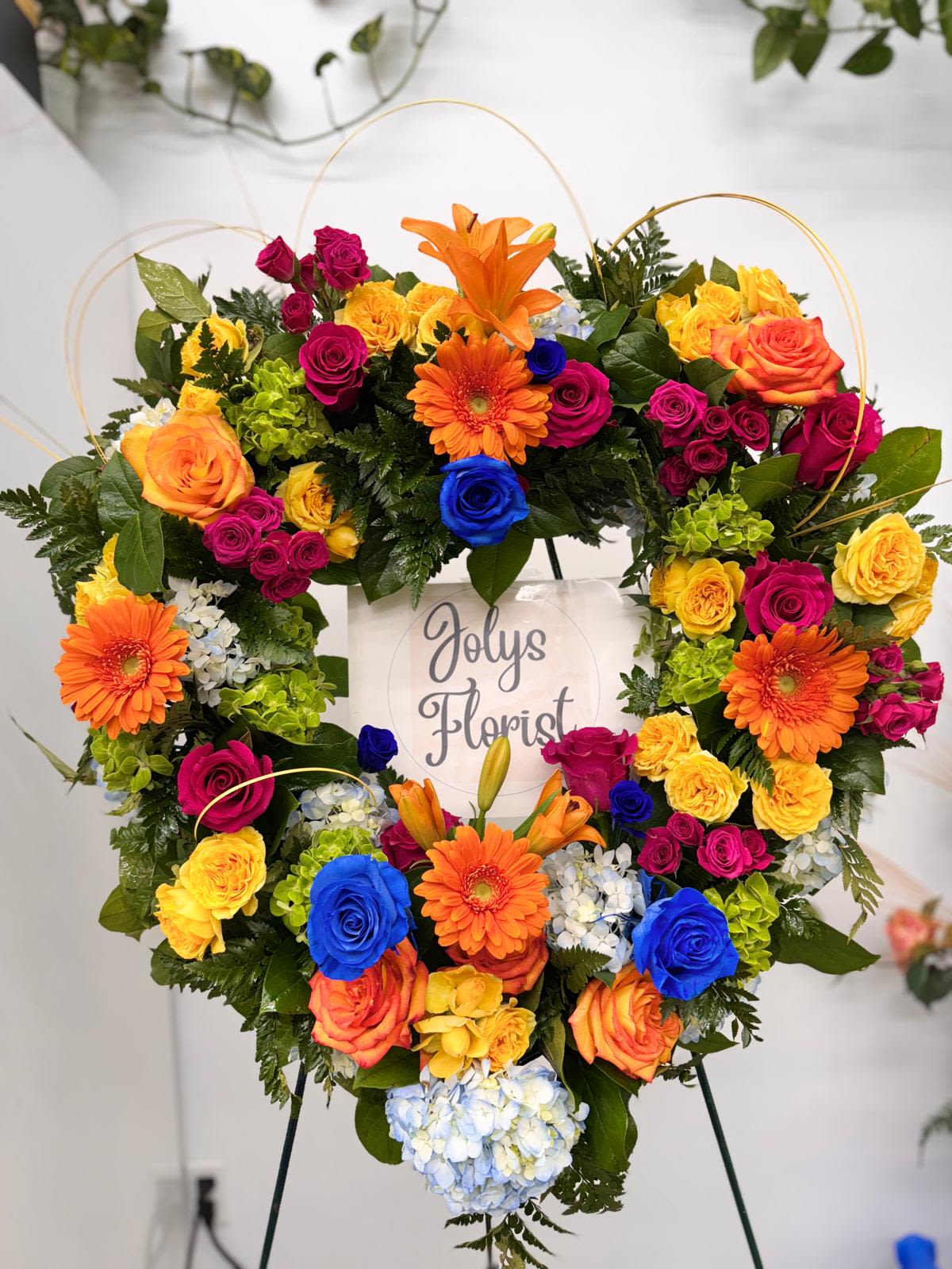 Heart-shaped floral wreath with multicolored roses and gerbera daisies