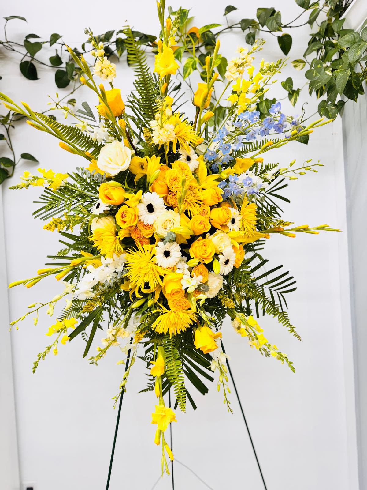 Tall yellow and white floral spray on a stand