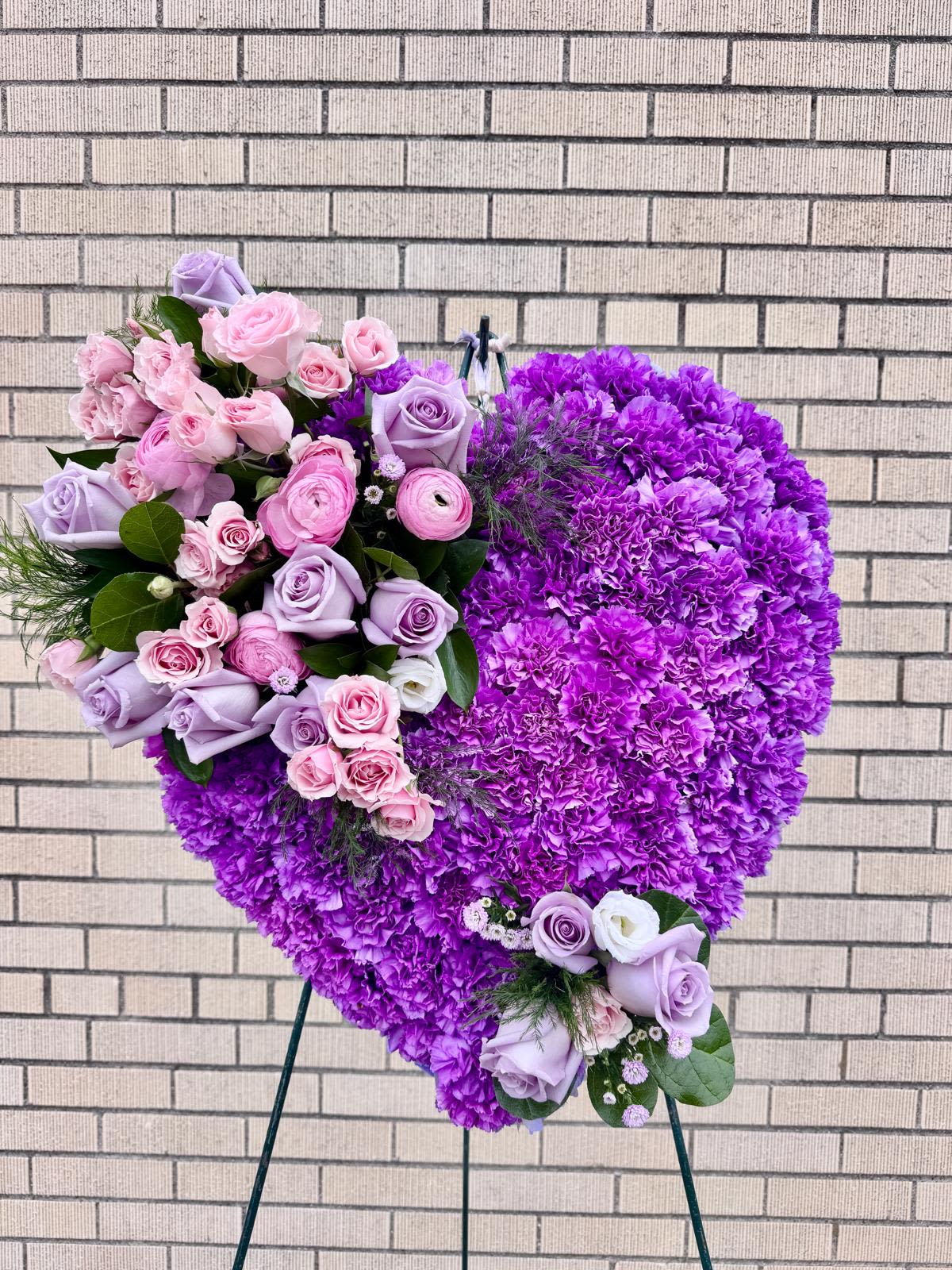 Heart-shaped purple floral standing arrangement with pink and lavender roses