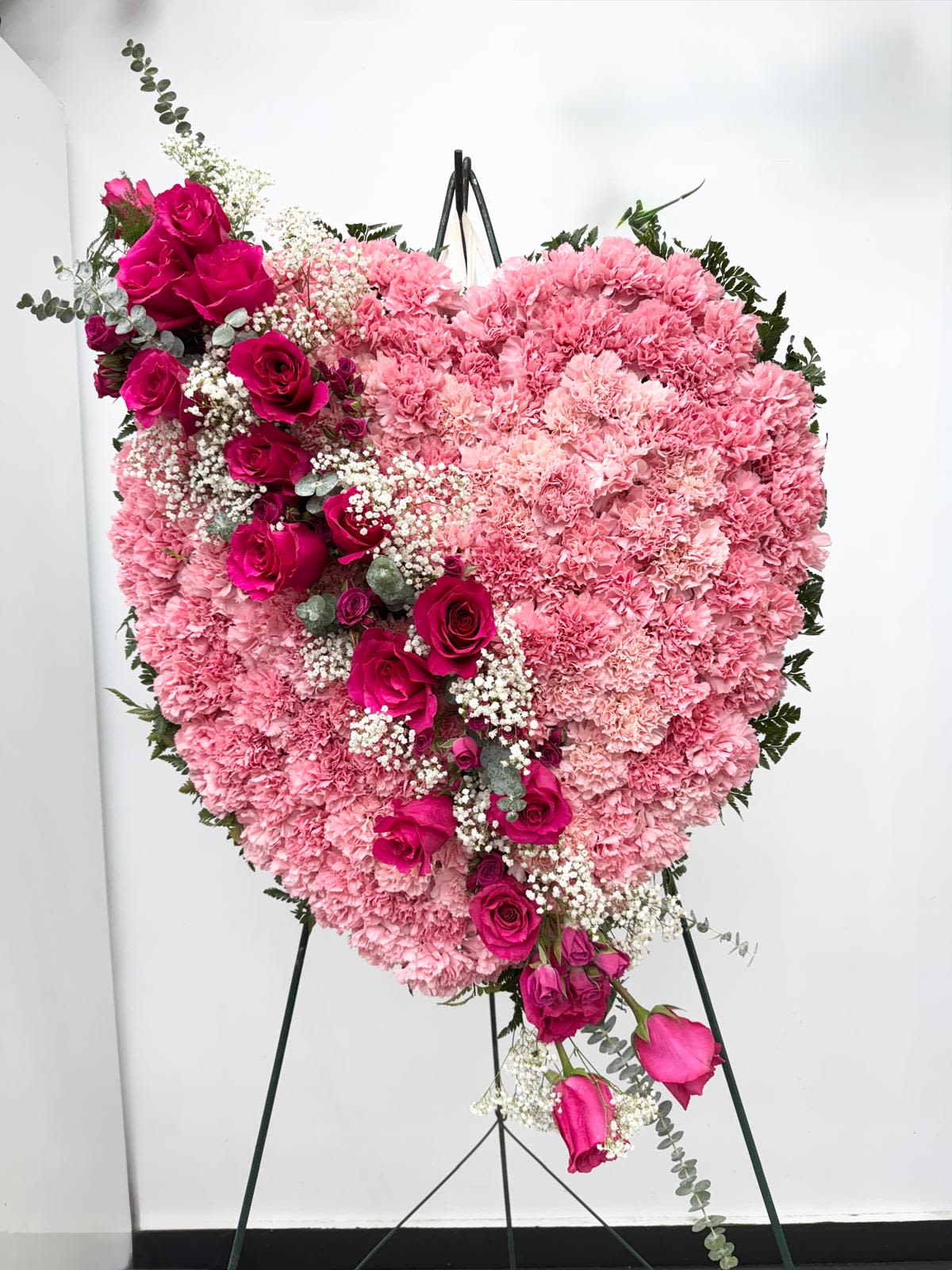 Heart-shaped pink floral standing arrangement with roses and carnations