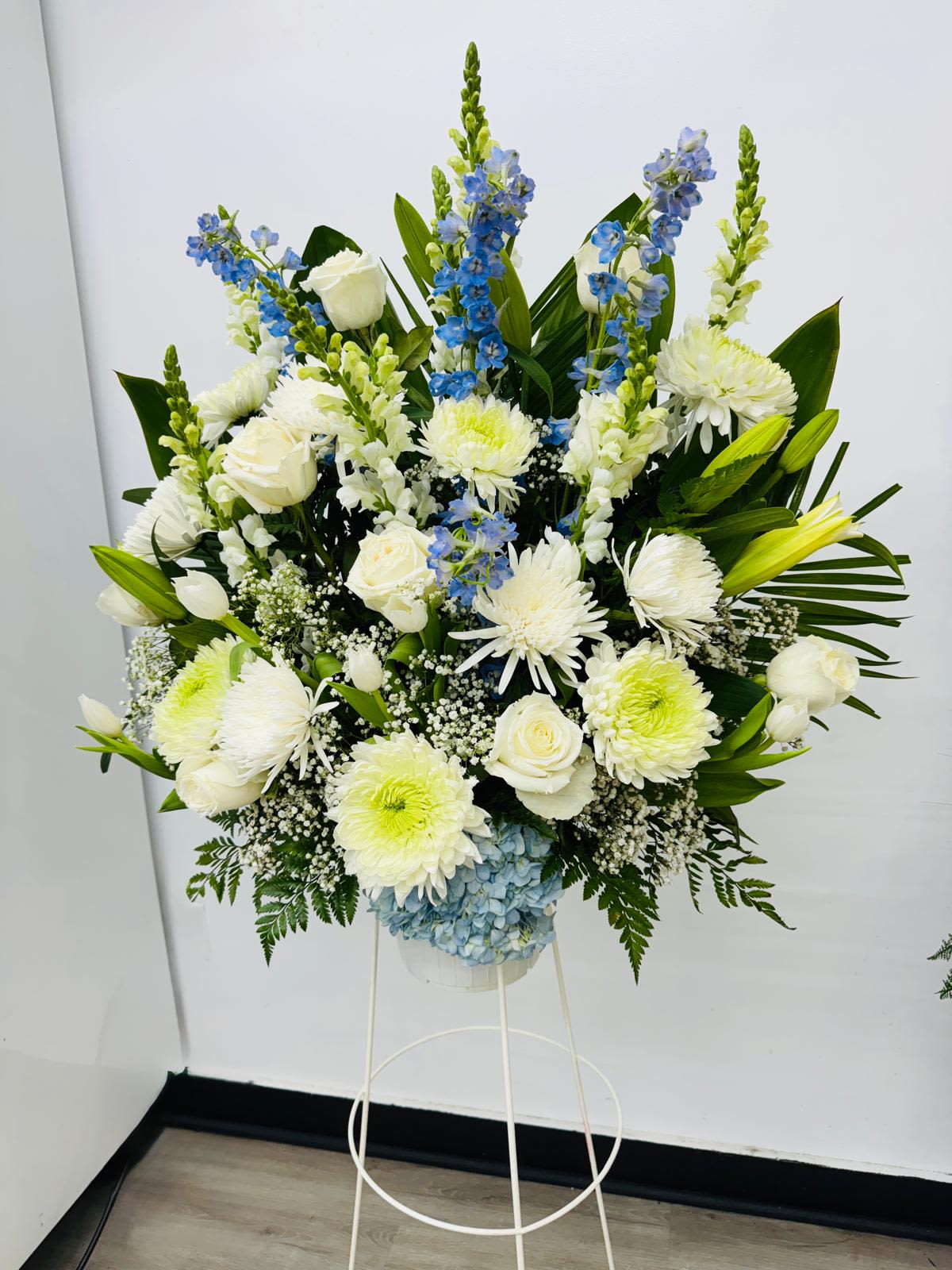 Large white and blue floral standing arrangement on a white stand