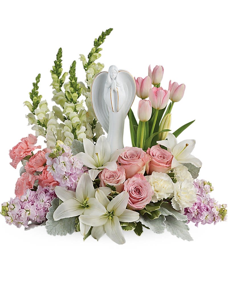 Pink and white floral arrangement with an angel figurine centerpiece
