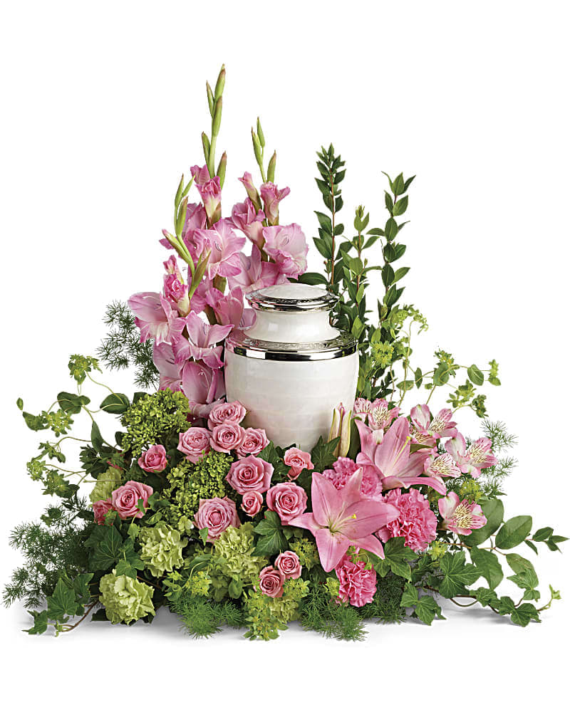 Pink flowers arranged around a white urn with greenery