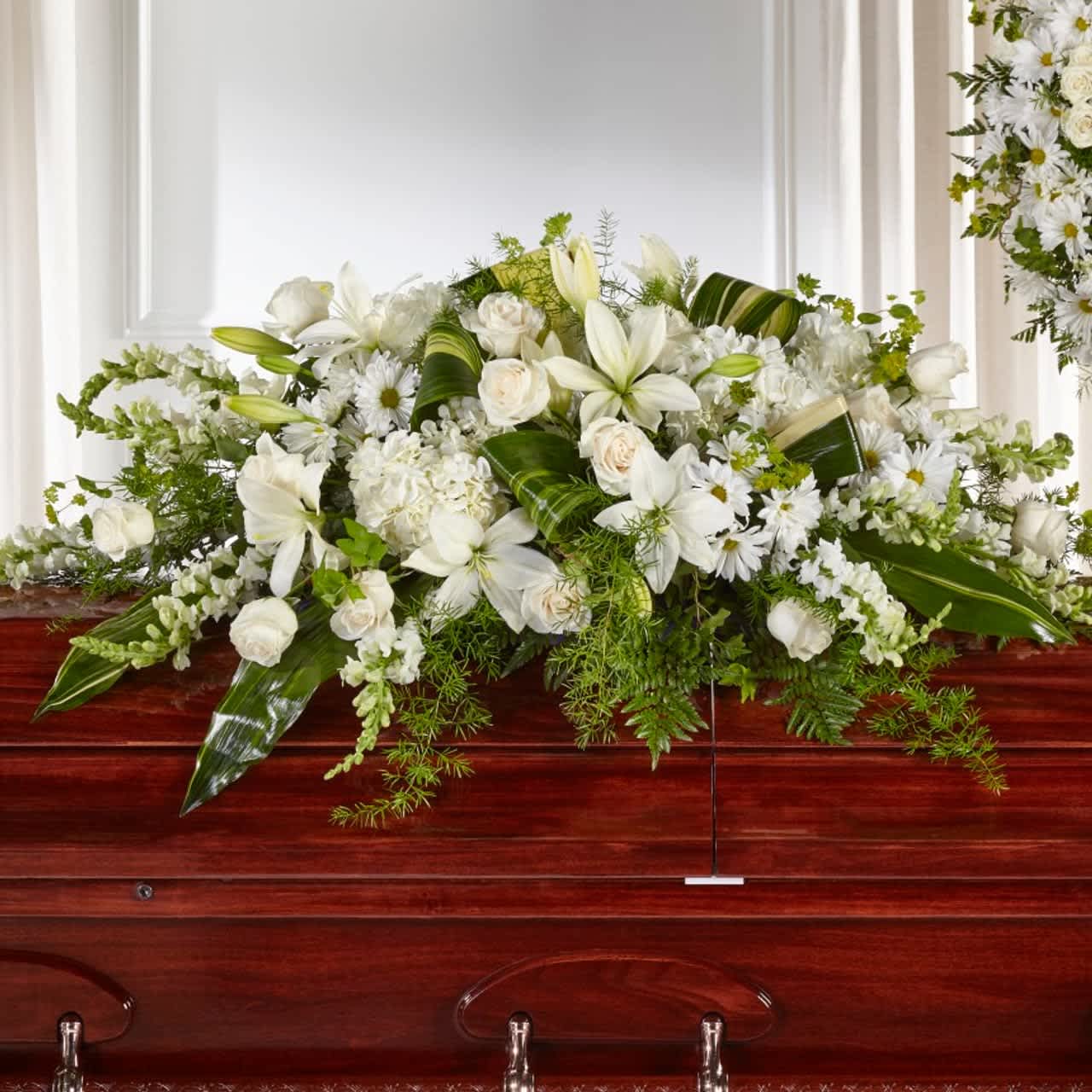 Serenity and Peace Casket Spray - Share serenity and peace with those who have recently lost a loved one with our Abundance™ Casket Spray. Composed of roses, snapdragons, lilies and hydrangea, this luminous collection of white and ivory hues comes together to create an elegant tribute. Spray is approximately 13"H x 49"W