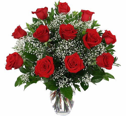 Bouquet of red roses with baby's breath in a clear glass vase