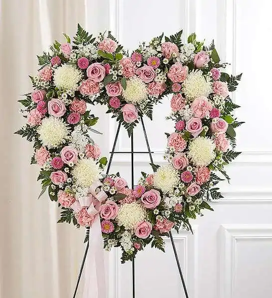 Always Remember Floral Heart Tribute - Pink &amp; White - They will always hold a special place in your heart. This sentiment is best captured with our standing, open heart-shaped arrangement in pink hues. Handcrafted by our caring florists with an assortment of graceful pink blooms, it is a magnificent tribute fitting for the funeral services.Open, heart-shaped arrangement of pink roses, matsumoto asters and carnations; white football mums, stock and monte casino; accented with baby’s breath and soft, lush greenery