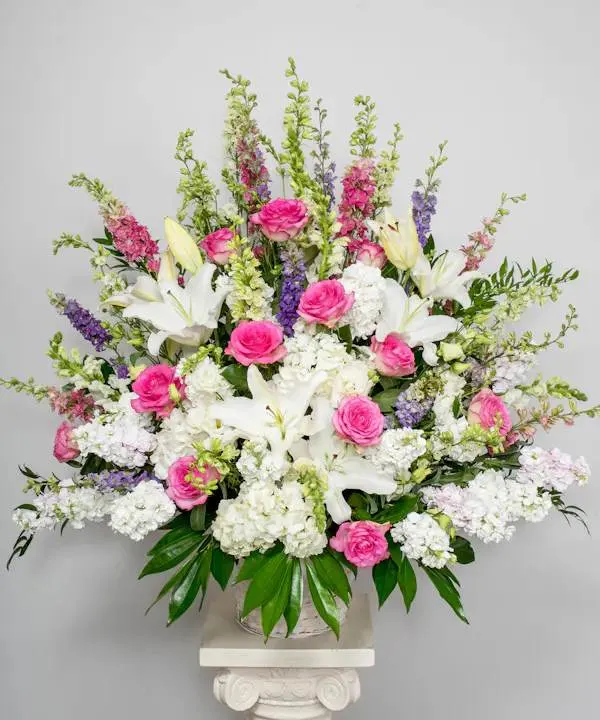  Our elegant pink and white standing basket  - For those who are grieving, a heartfelt gesture can mean so much. Our elegant pink and white standing basket arrangement will honor the memory of a loved one in a beautiful way. Artistically designed with a medley of pink blooms, this touching expression offers comfort and support when it’s needed most.