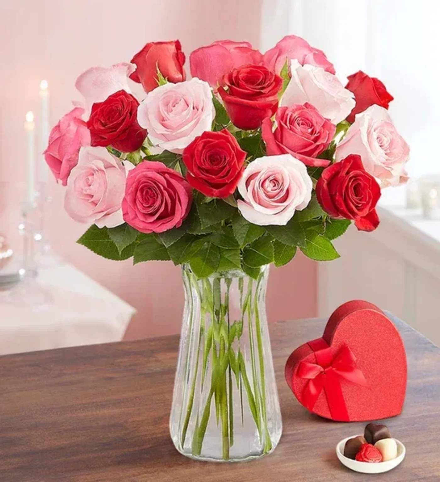 Bouquet of red, pink, and white roses in a clear glass vase