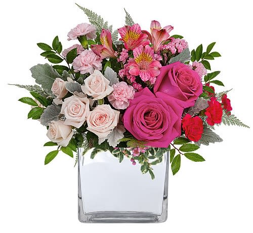 Pink and white rose bouquet in a clear square vase