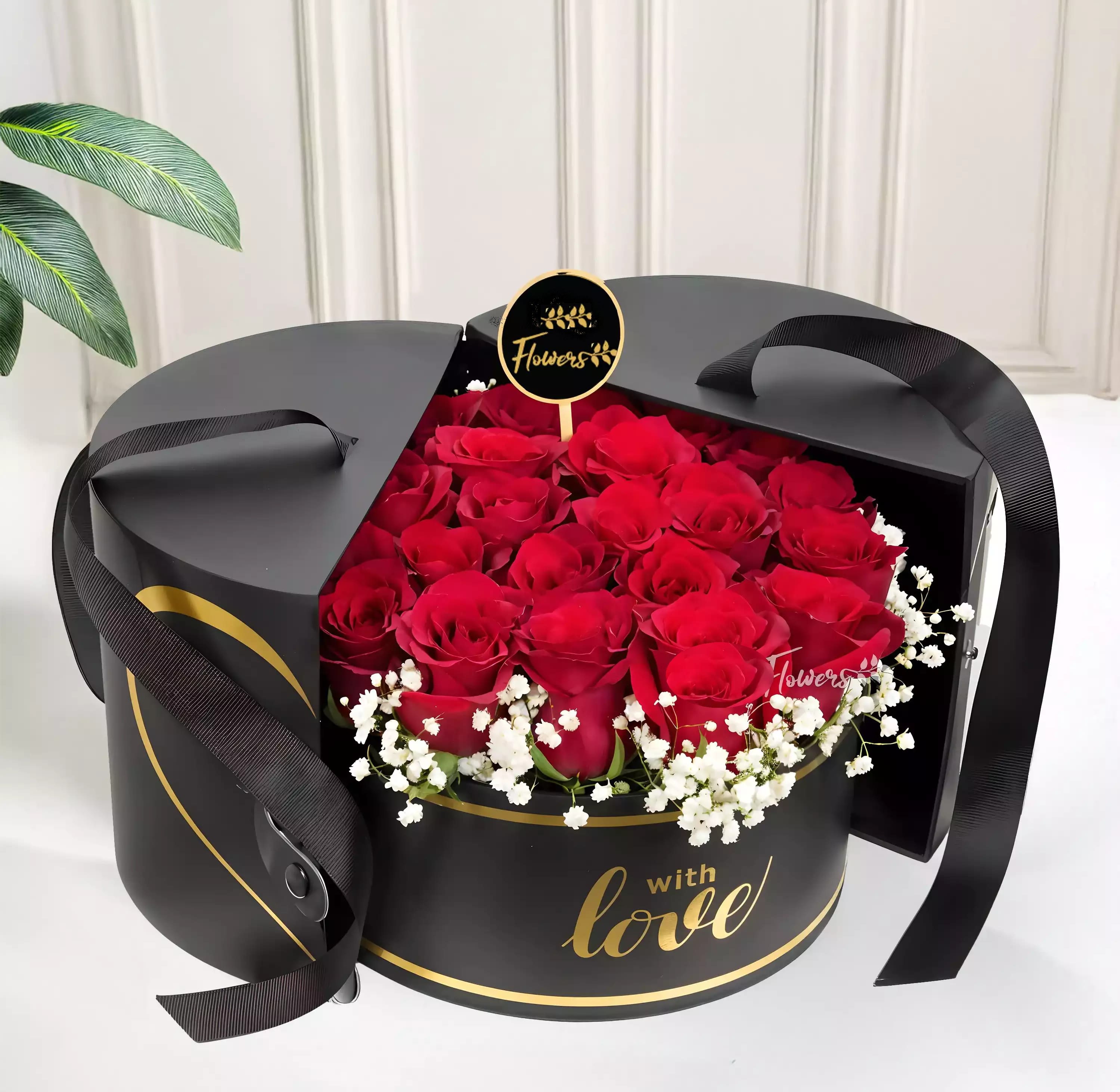 Red roses in a black round gift box with white baby's breath