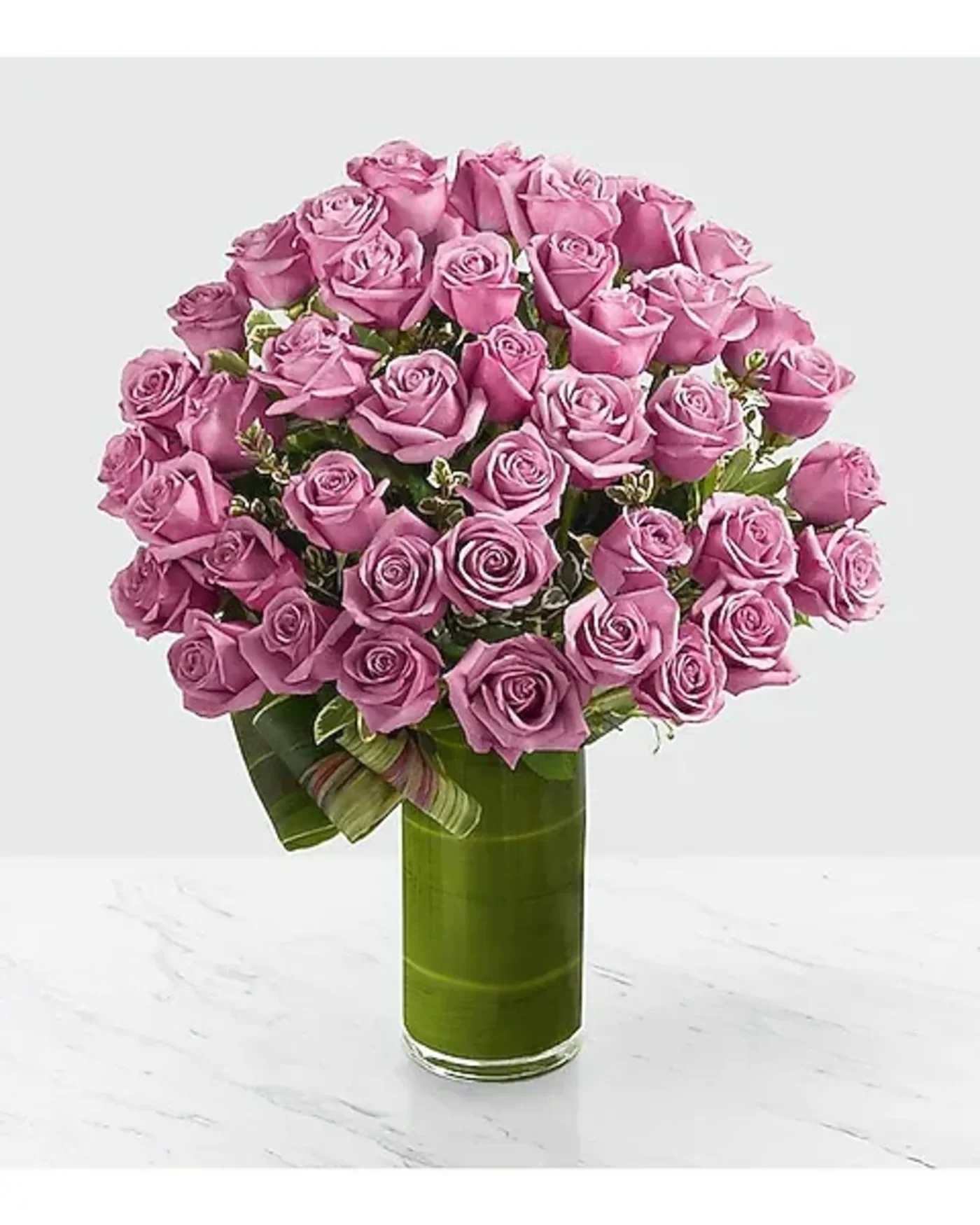Pink rose bouquet in a tall green glass vase