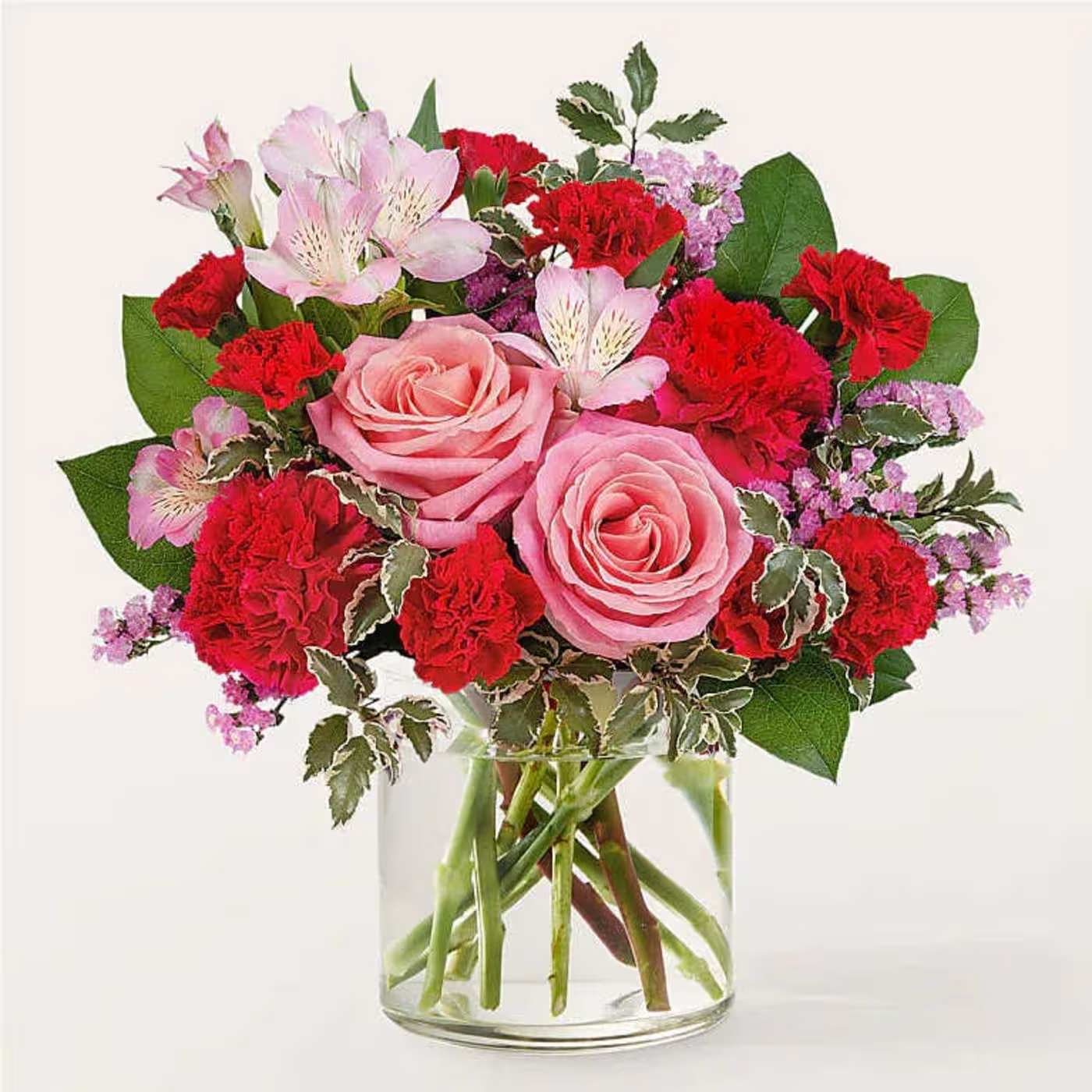 Pink roses and red carnations in a clear glass vase