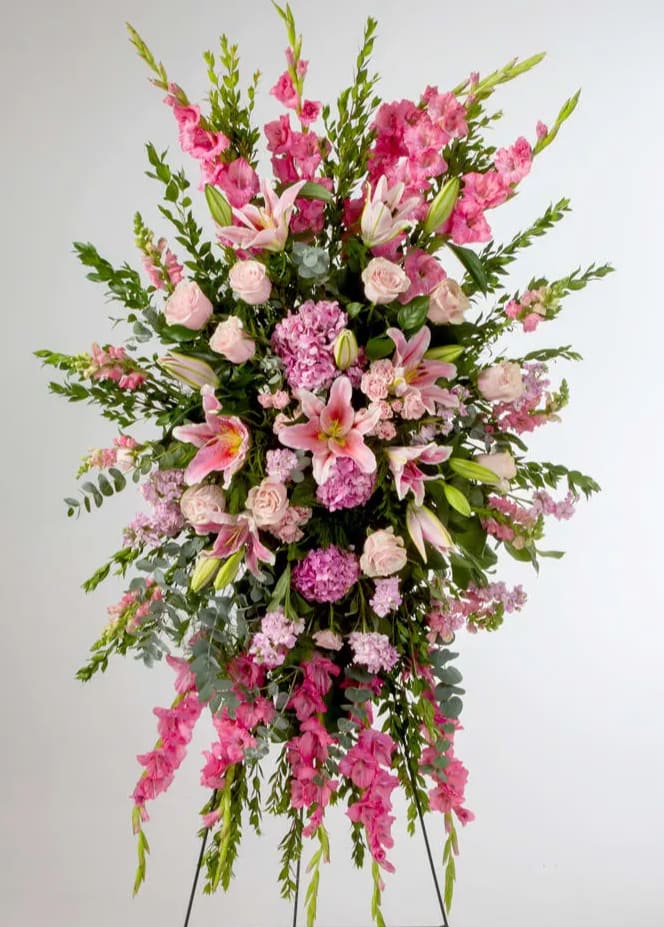Tall pink floral standing spray with lilies, roses, and greenery