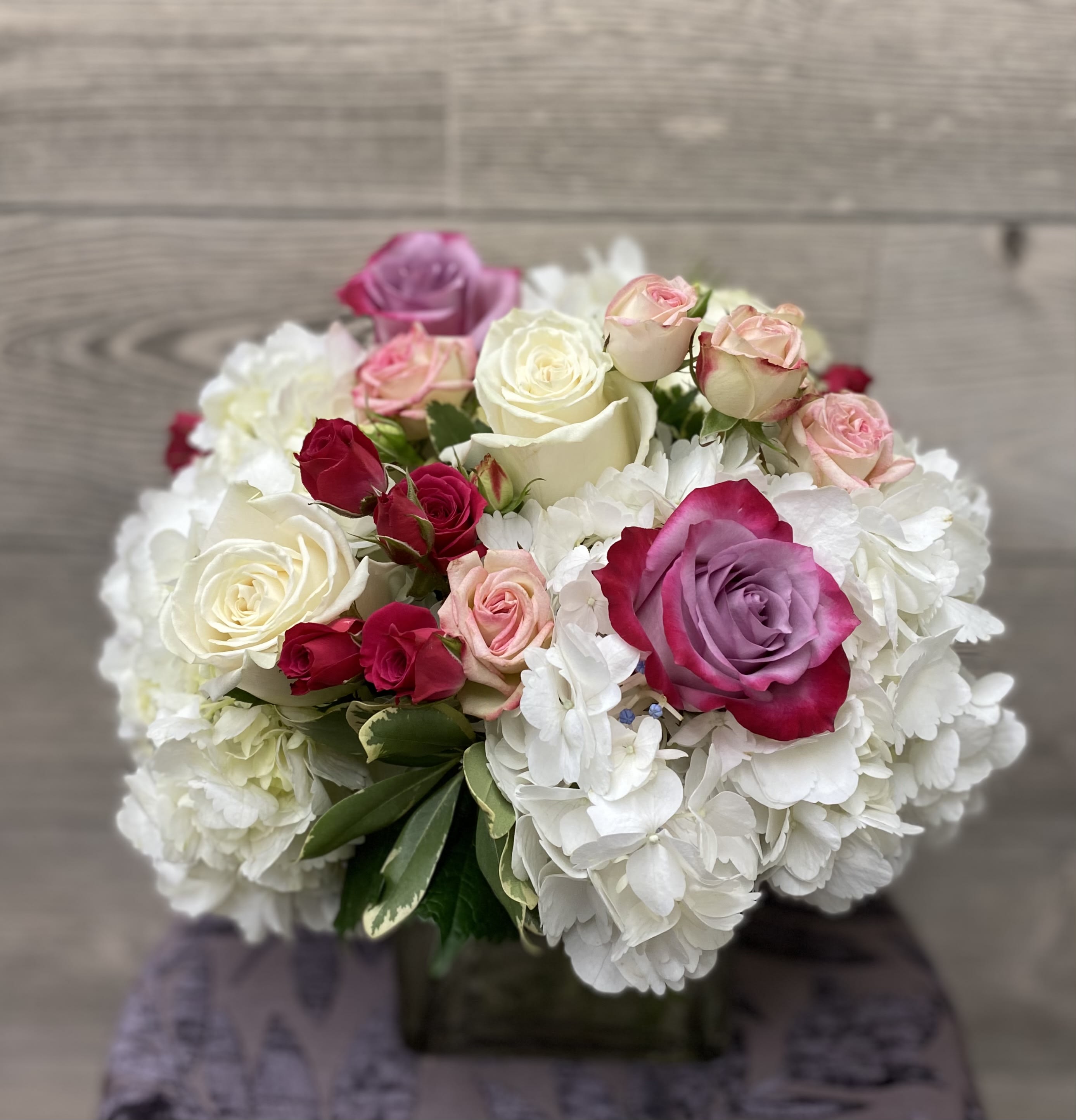 Home Sweet Home - Send a little love their way.    A square vase arrangement of hydrangeas, roses and spray roses.  