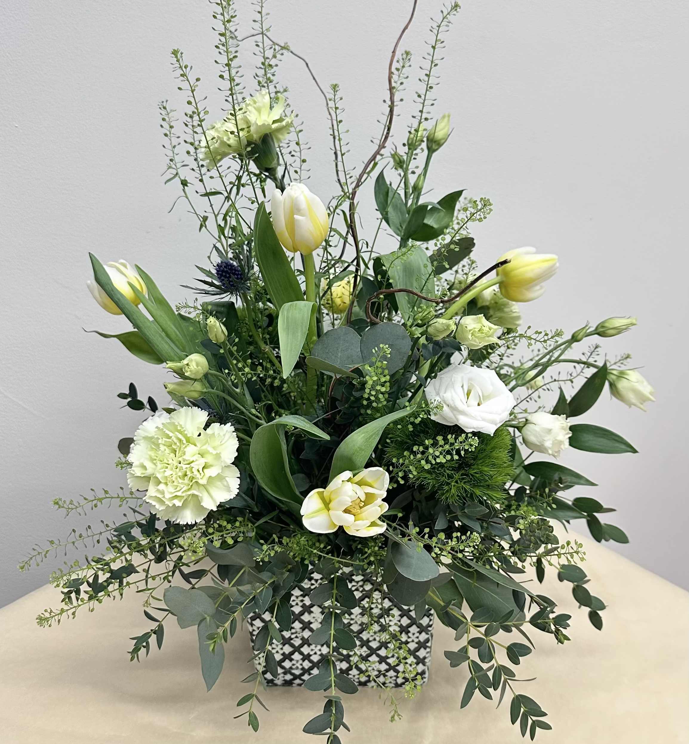 Wild by Nature - A whimsical mix of green, white and creamy wildflowers arranged in a ceramic planter.  