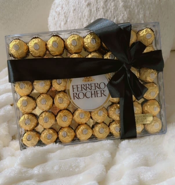 Box of Ferrero Rocher chocolates tied with a black ribbon