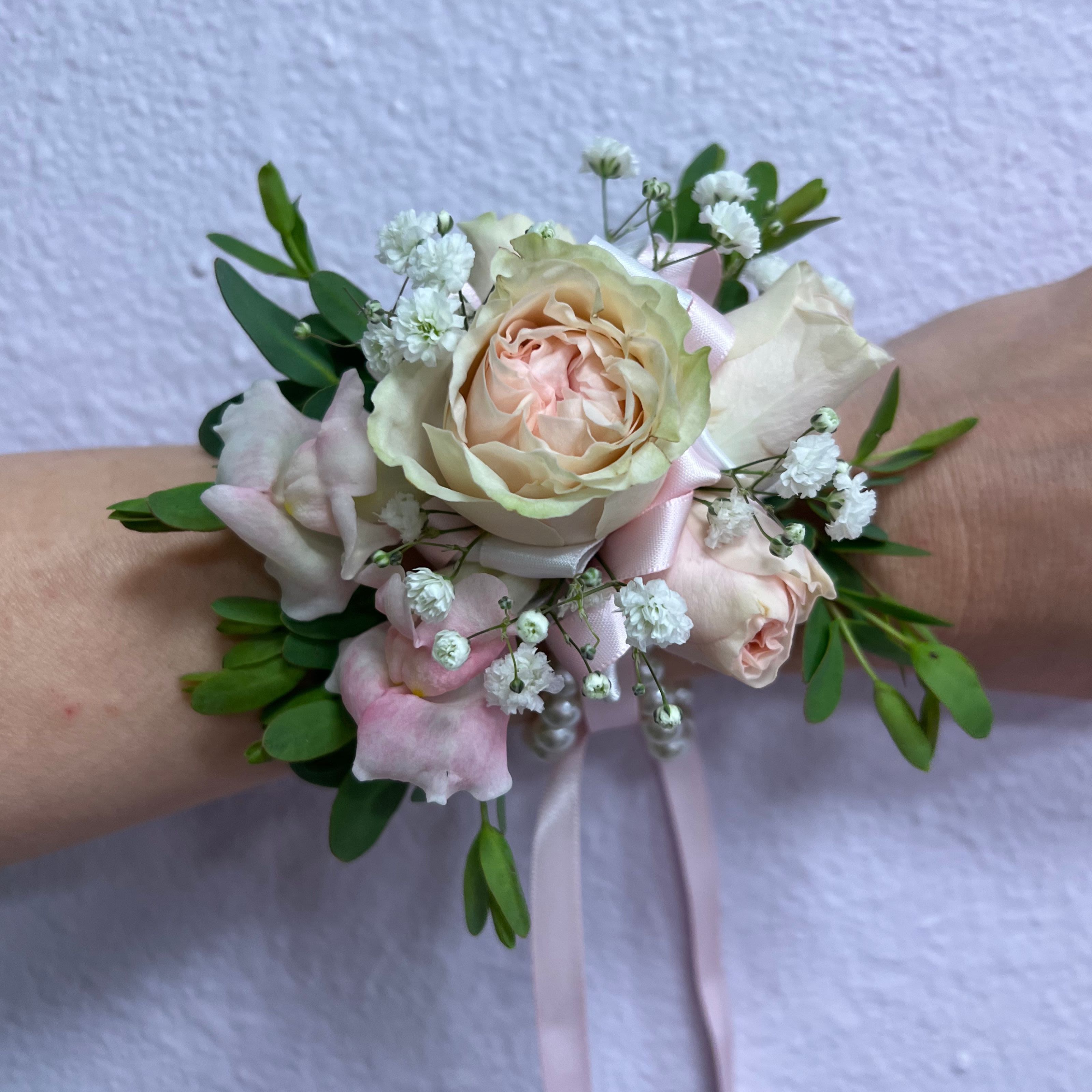 Pastel rose wrist corsage with baby's breath and ribbon