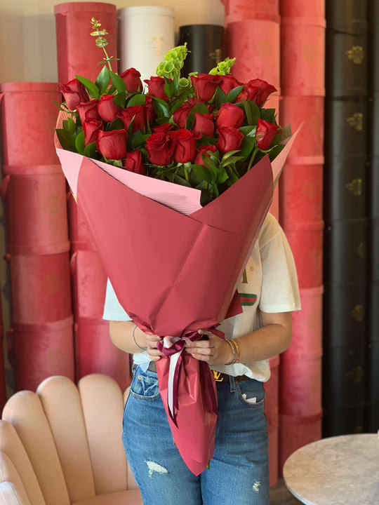 Large bouquet of red roses wrapped in pink paper