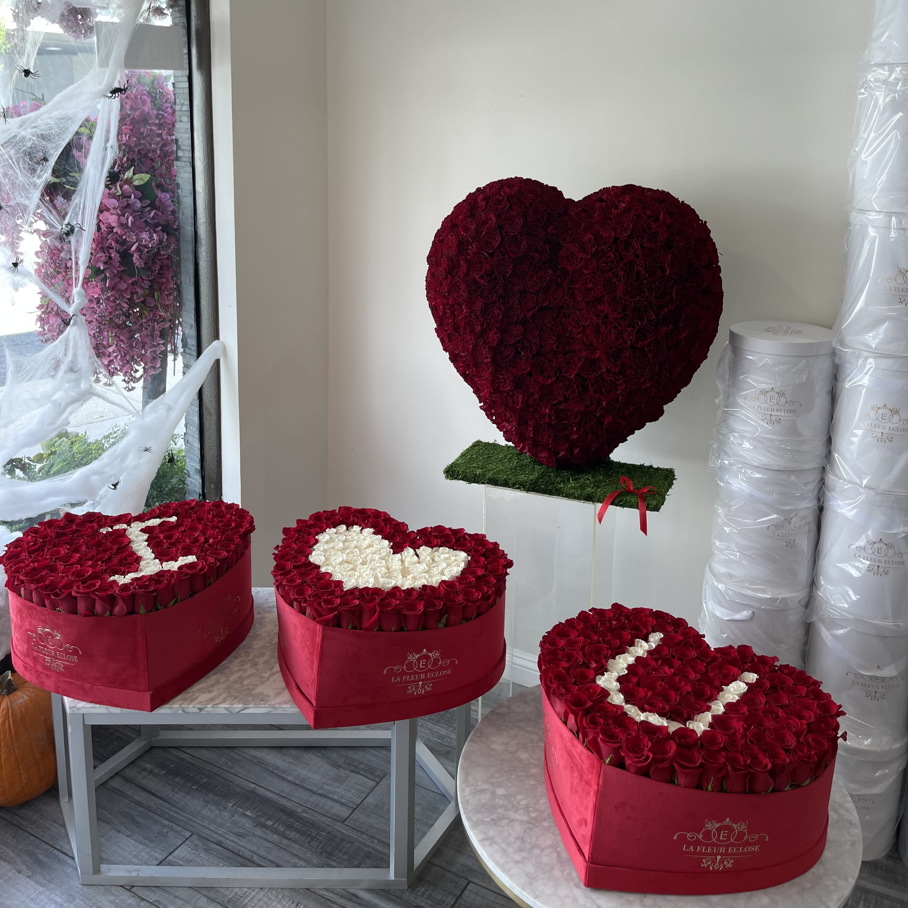 Heart-shaped rose arrangements in red boxes, including one large heart display