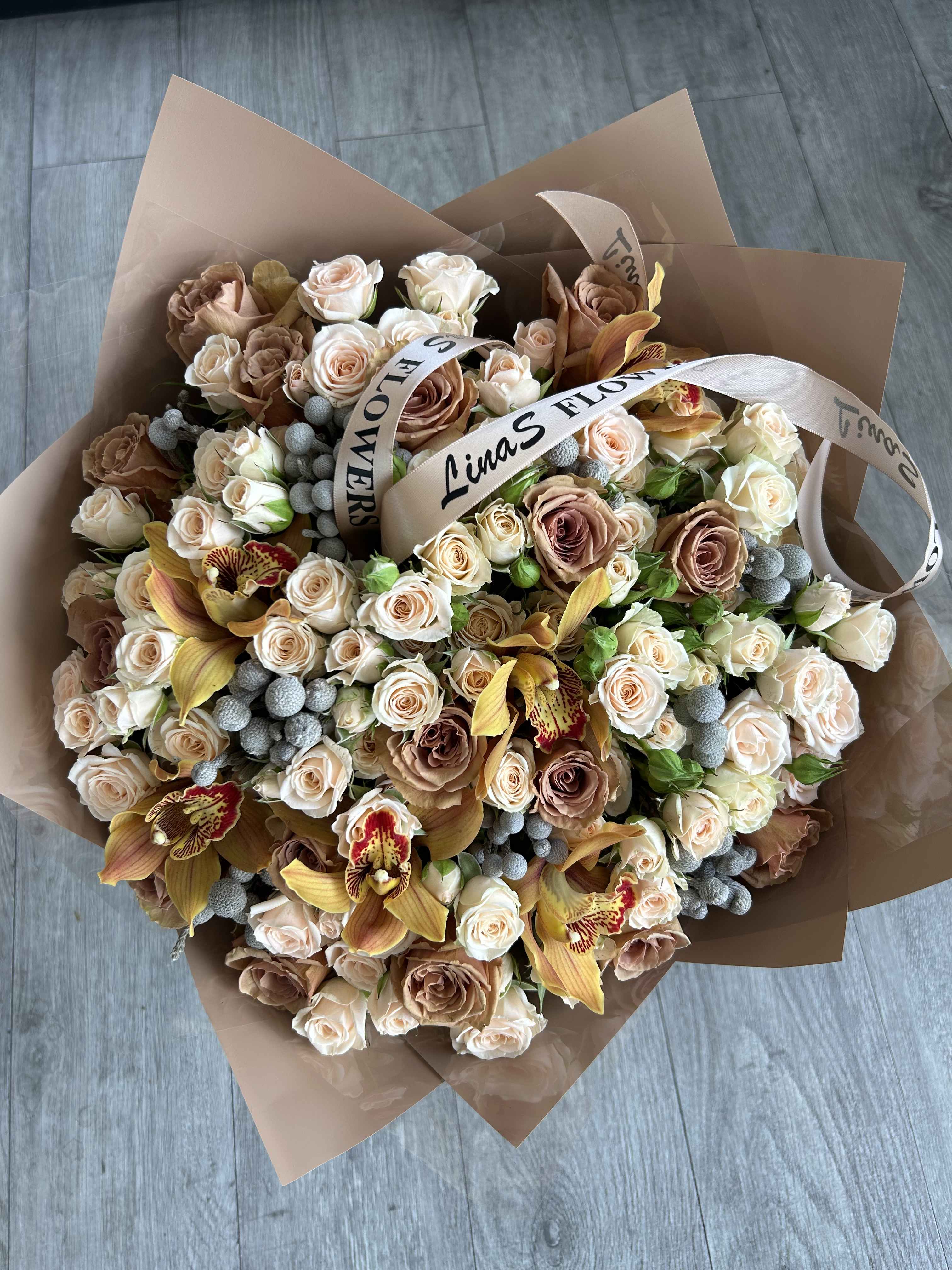 Large bouquet of blush and cream roses with orchids and ribbon