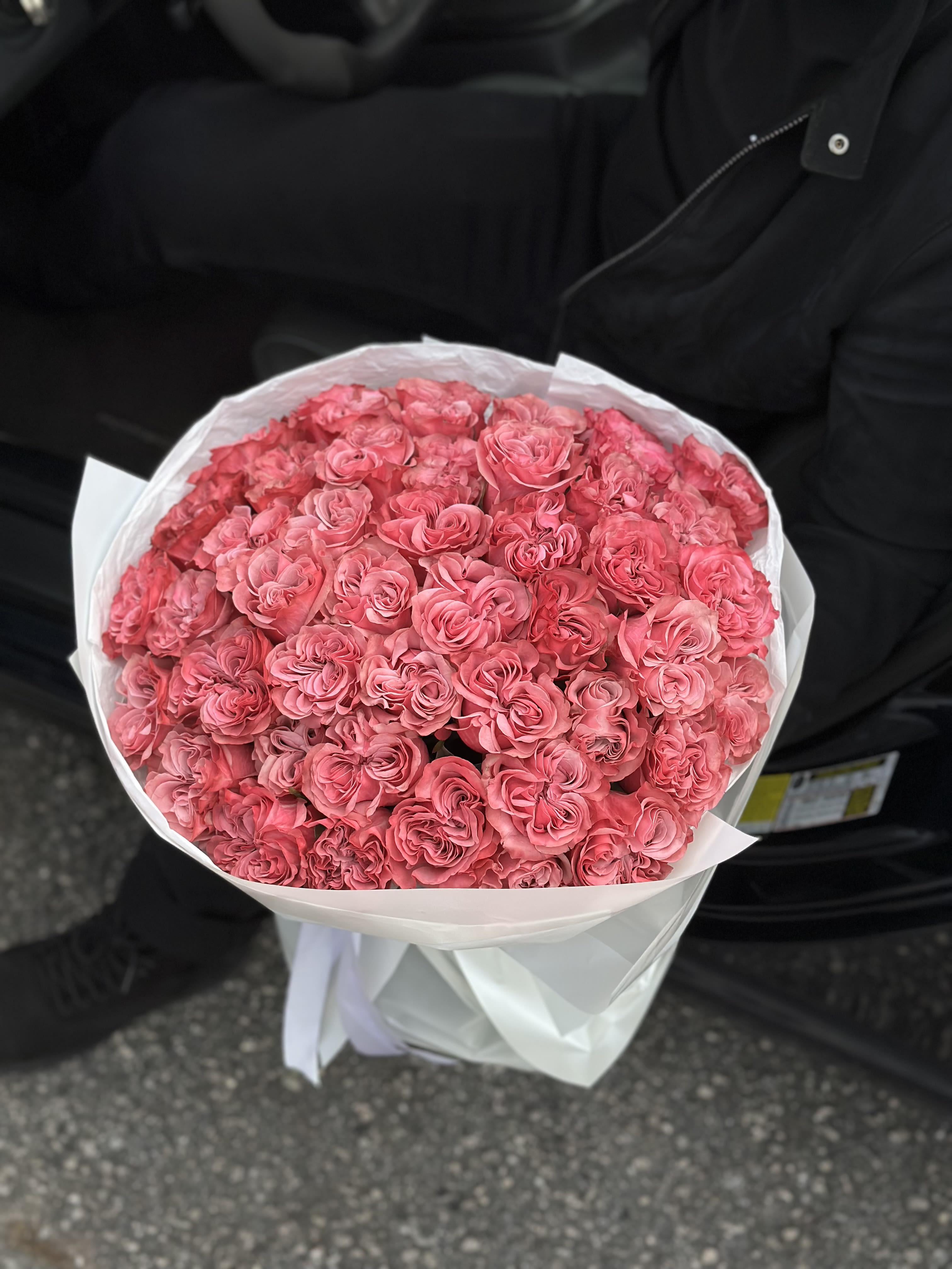 Large bouquet of pink roses wrapped in white paper