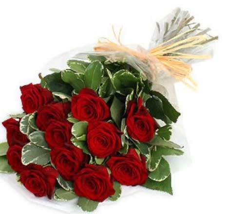 Bouquet of red roses wrapped in clear paper with a raffia bow