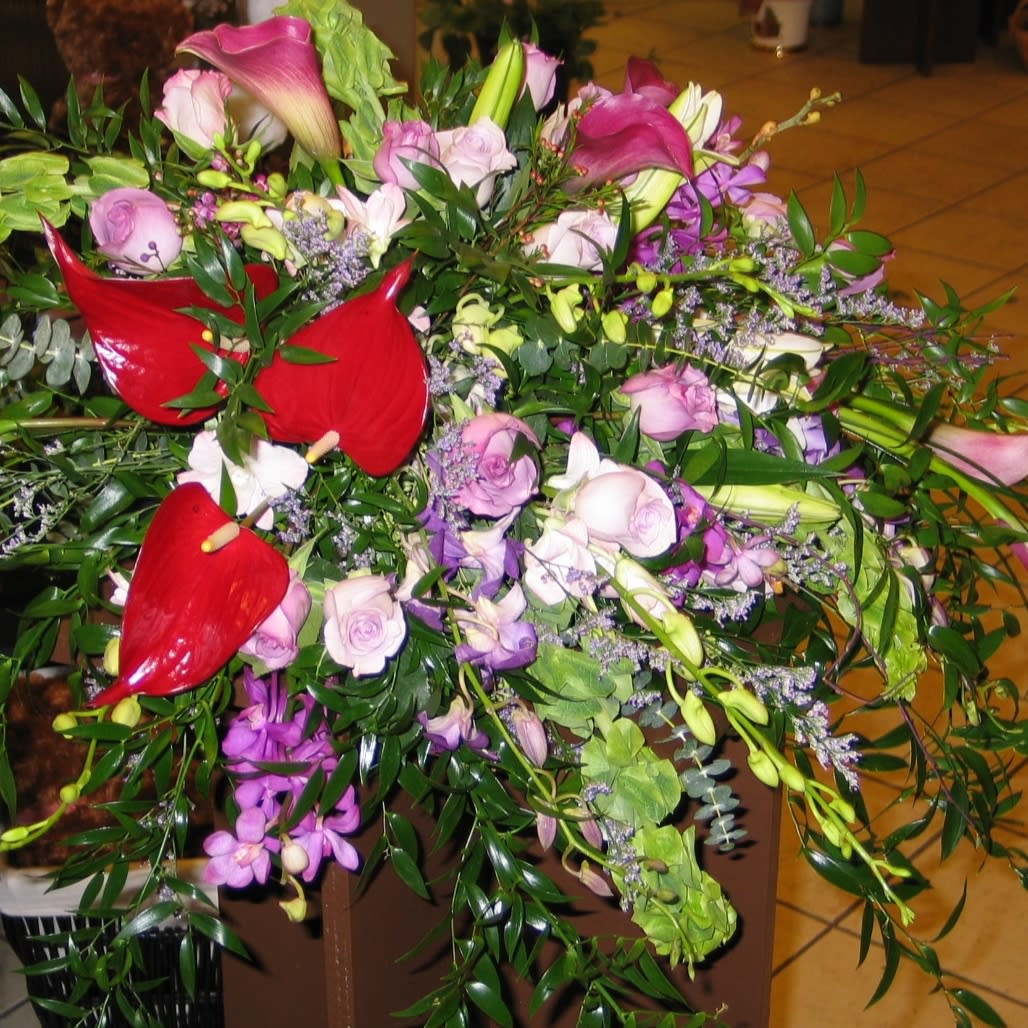 Mixed bouquet with red anthuriums, pink roses, and purple orchids