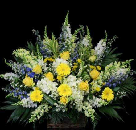 Large yellow and white floral arrangement in a basket