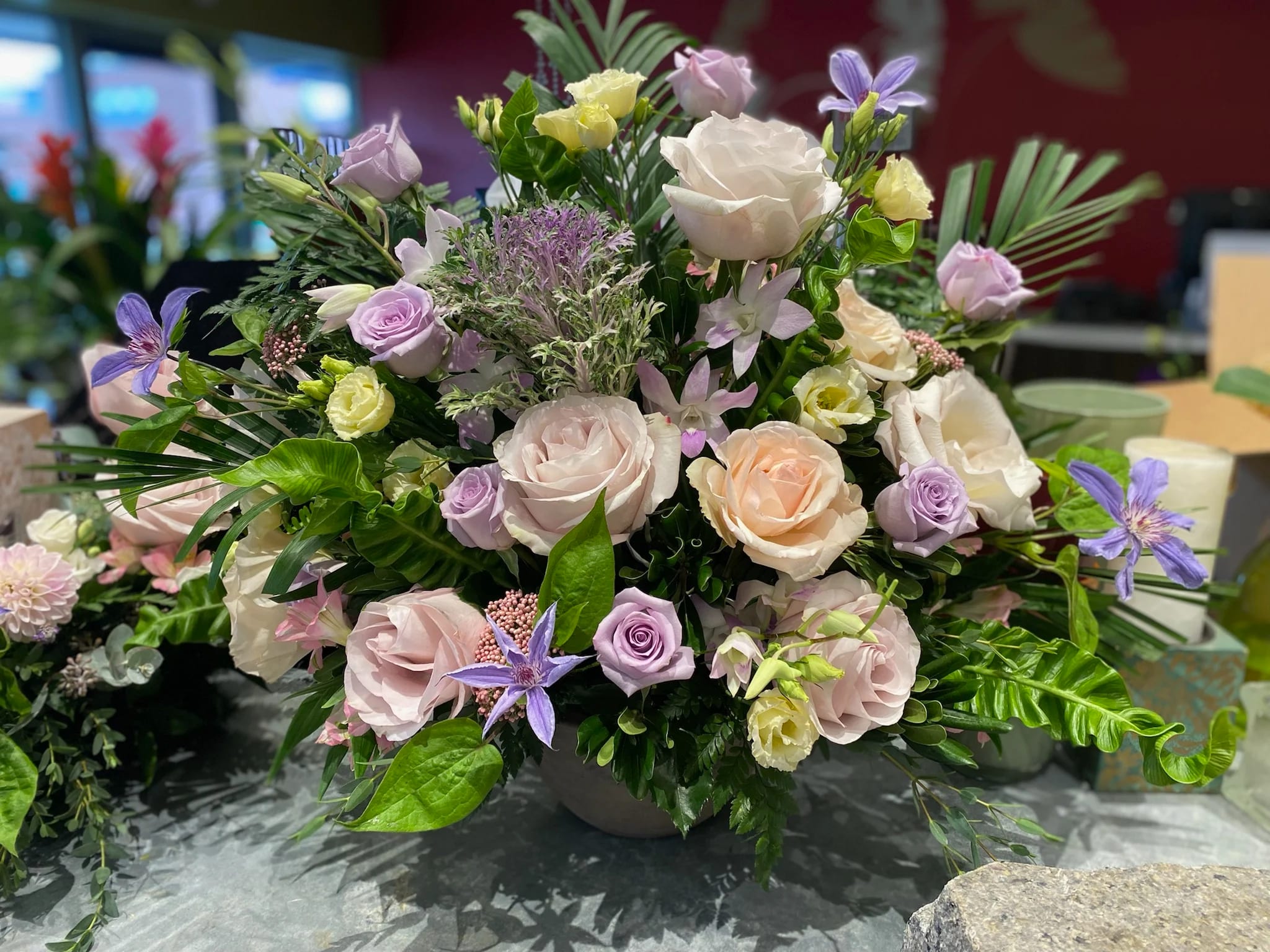 Mixed pastel bouquet with roses and purple star-shaped flowers in a vase