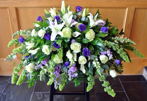 Large white and purple floral spray with cascading greenery