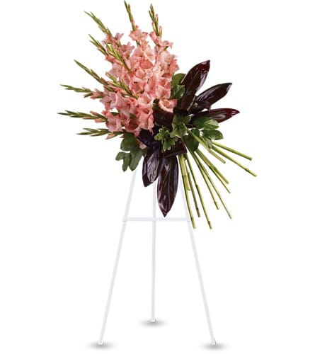 Pink gladiolus arrangement on a white stand with dark foliage